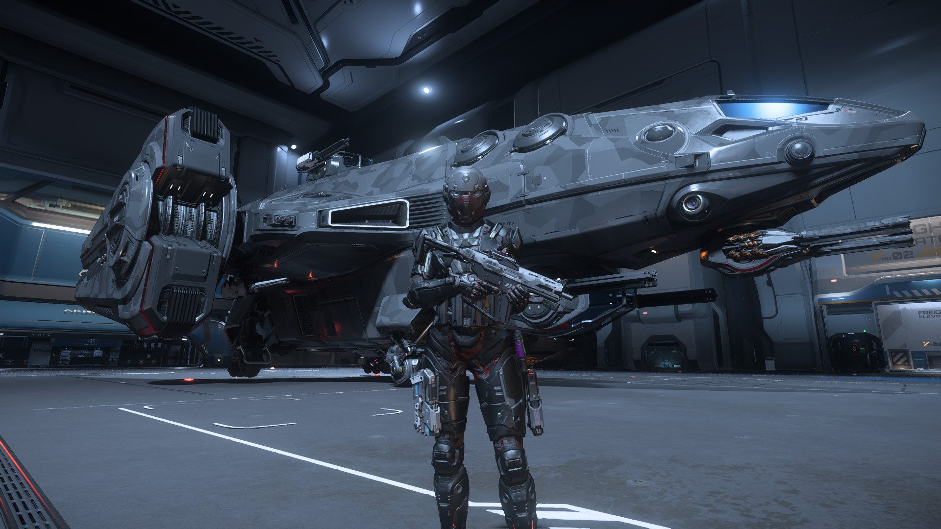 Un joueur en armure lourde, fusil en main, devant un vaisseau posé dans un hangar, dans Star Citizen